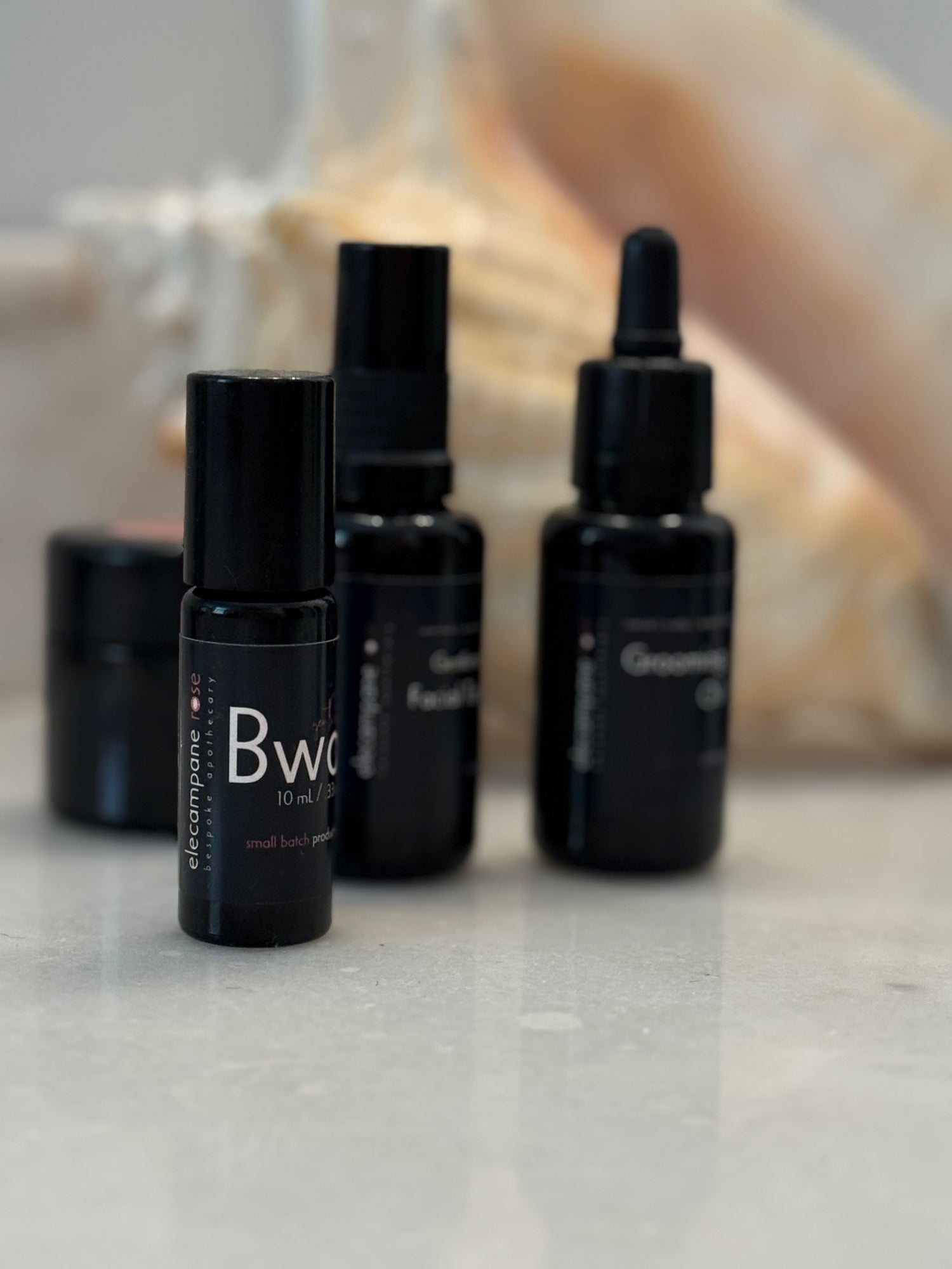 Black skincare bottles with visible branding on a neutral background